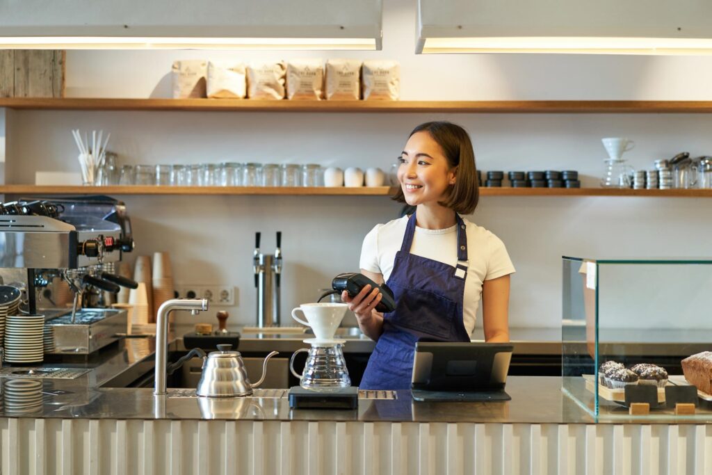 portrait of smiling asian girl barista standing near coffee brewing kit making filter in cafe 1